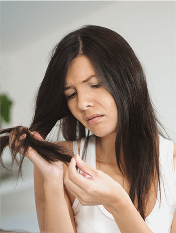 A woman is combing her hair with a brush.